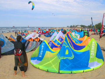 A beach packed full of kiteboarding gear