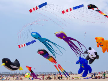 The Windjammers fly a routine against a backdrop of giant kites at the Great Lakes Kite Festival The Windjammers fly a routine against a backdrop of giant kites at the Great Lakes Kite Festival